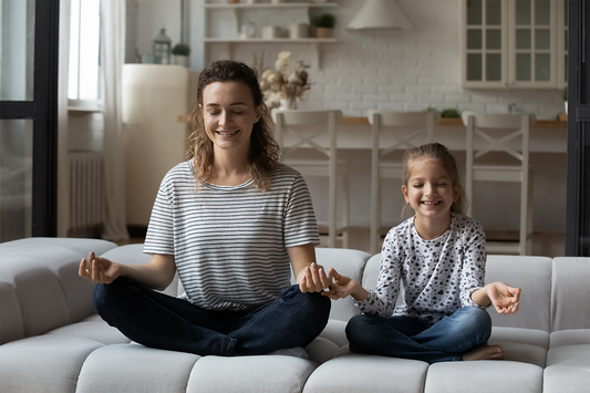 Mother and Daughter meditating on a couch